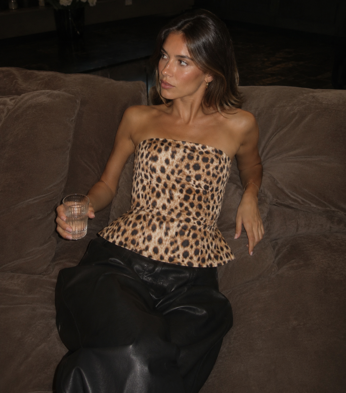Cheetah corset top and black leather pants on a couch